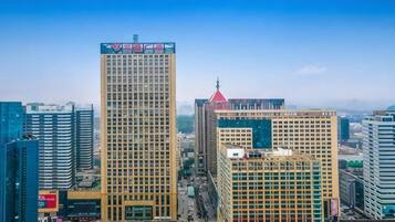 A cityscape with multiple high-rise buildings, including a prominent building with a red roof and another with a large advertisement on the top.