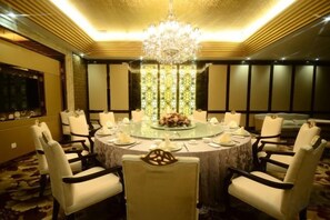 A round dining table with chairs, a chandelier, and a floral centerpiece. - Wenshang Changjiang Hotel (Lanzhou)