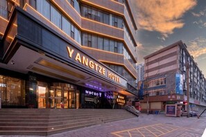A modern hotel with a prominent entrance, a visible staircase, and a clear view of the street.