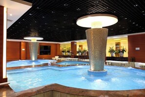 An indoor swimming pool with multiple lanes, surrounded by wooden walls and a ceiling with a grid pattern. - Fangzhou Hotel (Kunming)