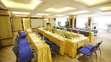A conference room with long tables, blue chairs, and a whiteboard.