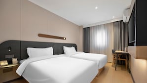 A hotel room with two beds, a desk, a chair, a TV, and a window with curtains. - Jinjiang Inn (Beijing)