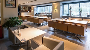 A modern restaurant with multiple seating areas, including tables and booths, and a bar area with a counter. - Jinjiang Inn (Beijing)