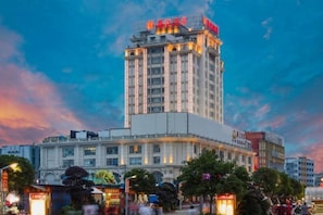 A multi-story hotel with a prominent sign at the top, surrounded by other buildings and trees. - Zunyue Hotel (Anqing Ancient City Renmin Road Pedestrian Street) (Anqing)