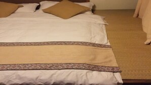 A hotel room with a bed, pillows, and a carpeted floor. - Cabin 7 Inn (Dali)