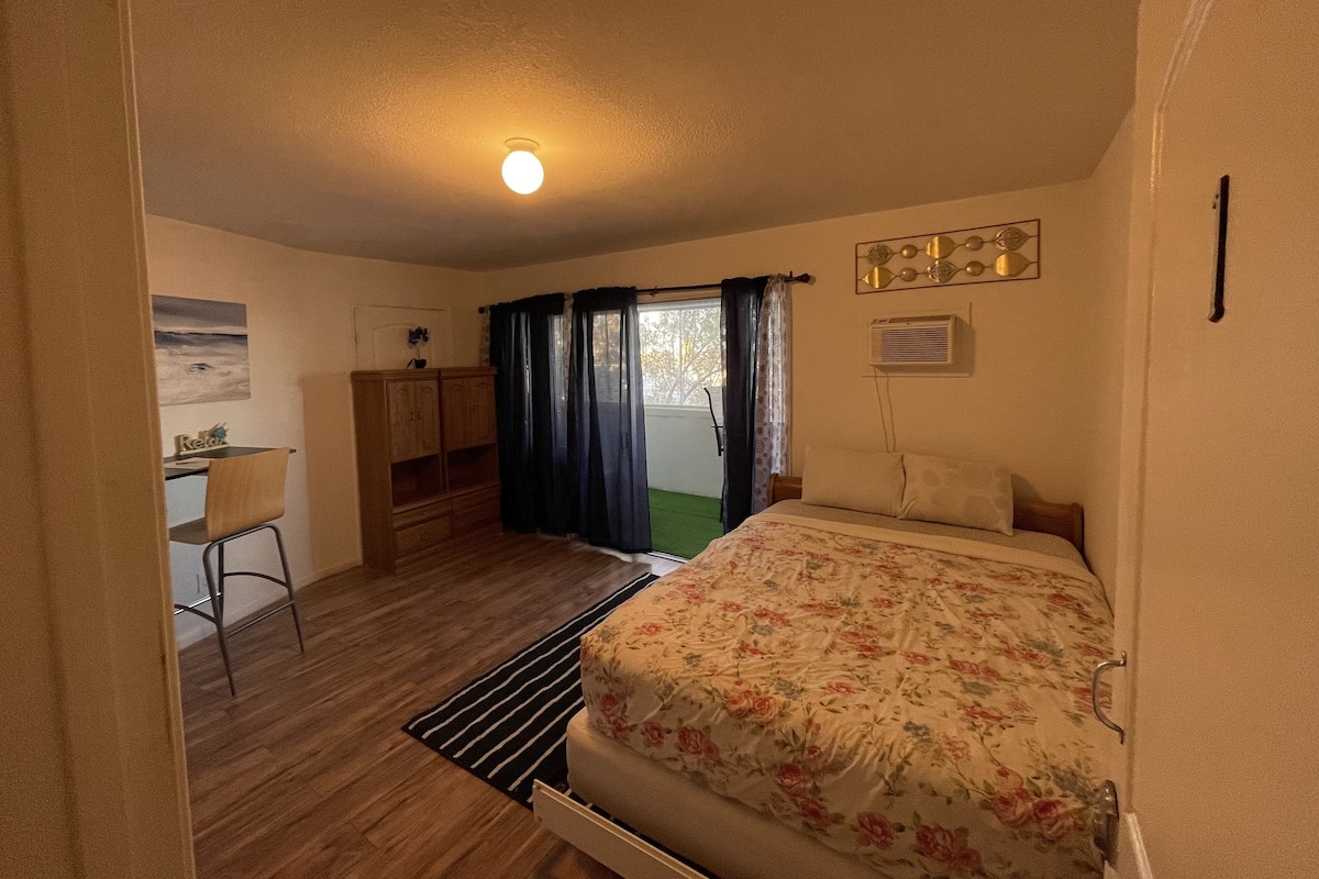 Una habitación pequeña con cama, escritorio y silla.