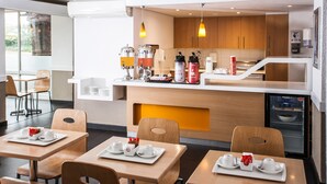 A modern cafe with wooden furniture, a coffee station, and a view of the outdoors. - SUN1 Berea (Johannesburg)