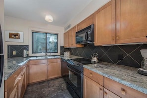 Condo luxo, 1 quarto | Cozinha privada | Geladeira, micro-ondas, fogão, cooktop