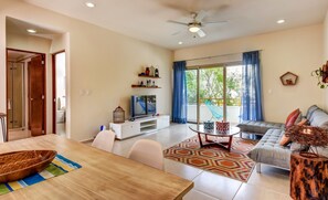 A modern living room with a TV, sofa, and dining area.