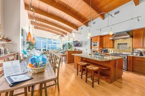 Una cocina amplia con armarios de madera, una isla grande e iluminación colgante.