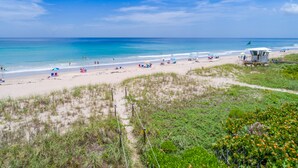 A beach with a lifeguard tower, sandy beach, and ocean view.