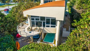 A modern house with a pool, a deck, and a view of the surrounding area.