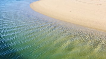 Una playa cerca, sillas reclinables de playa, toallas de playa