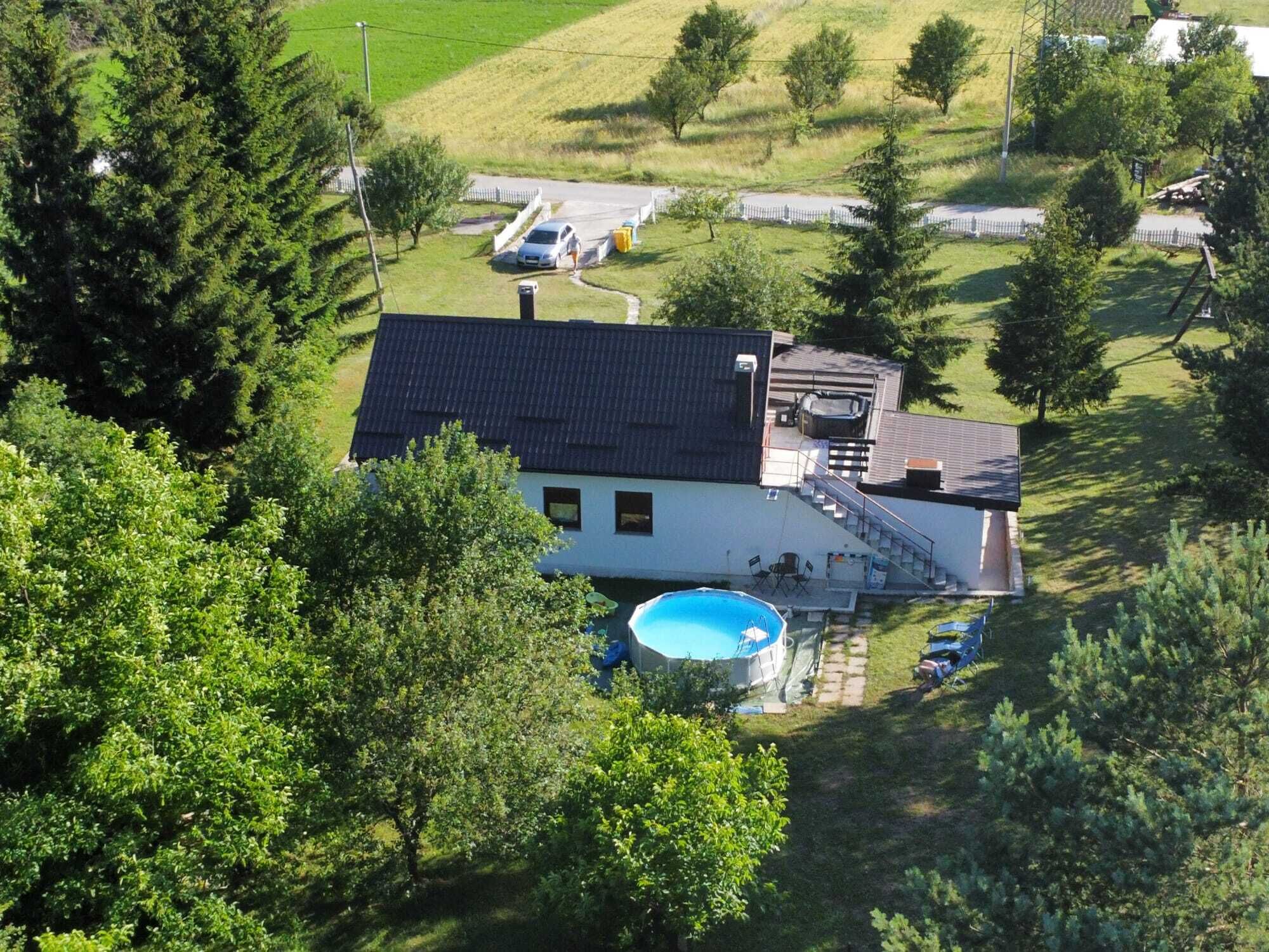 A house with a swimming pool, a covered patio, and a fenced yard.