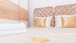 A bed with a headboard, pillows, and a blanket with a logo. - Villa Pearl of the Adriatic - discover some undiscoverd(10 meters from sea) (drvenik mali)