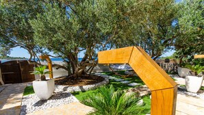 A landscaped garden with a palm tree, a wooden pergola, and a stone pathway. - Villa Pearl of the Adriatic - discover some undiscoverd(10 meters from sea) (drvenik mali)