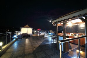 Une terrasse sur le toit comprenant un espace bar, des sièges et une partie abritée.