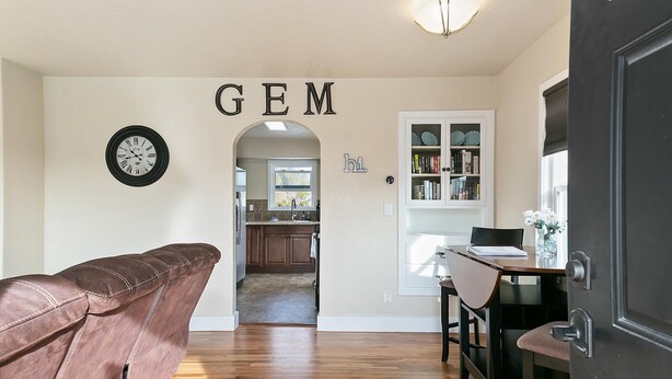 A hallway leading to a kitchen with a clock, a bookshelf, and a door labeled "GEM". - This is Boise's Gem! (Boise)