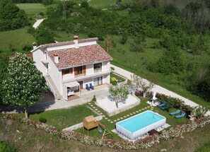 A two-story house with a swimming pool, a covered patio, and a garden. - Apartment with pool, garden and children's playground (Karojba)
