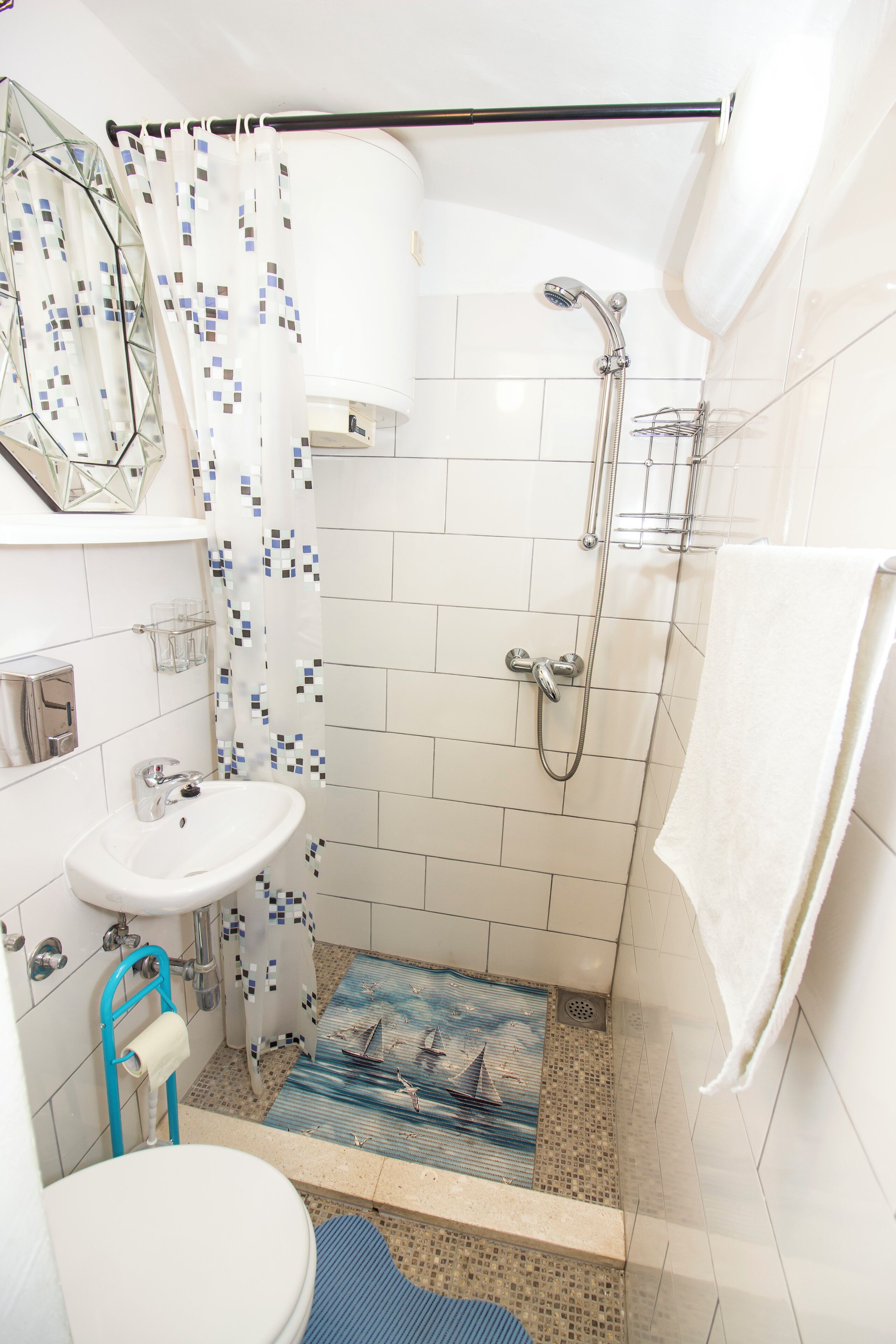 Un baño con ducha, lavamanos e inodoro.