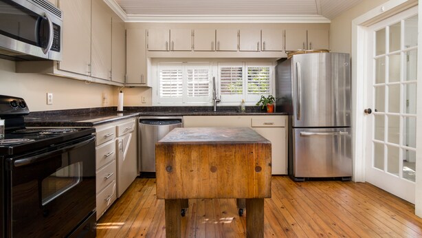 A kitchen with wooden cabinets, a stainless steel refrigerator, a wooden island, and a black stove. -  Charming One-Story 3BR 3BA Home Just Off The Oxford Square! Deck and Porch! (Oxford)