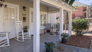A porch with white rocking chairs, a small table, and potted plants. -  Charming One-Story 3BR 3BA Home Just Off The Oxford Square! Deck and Porch! (Oxford)