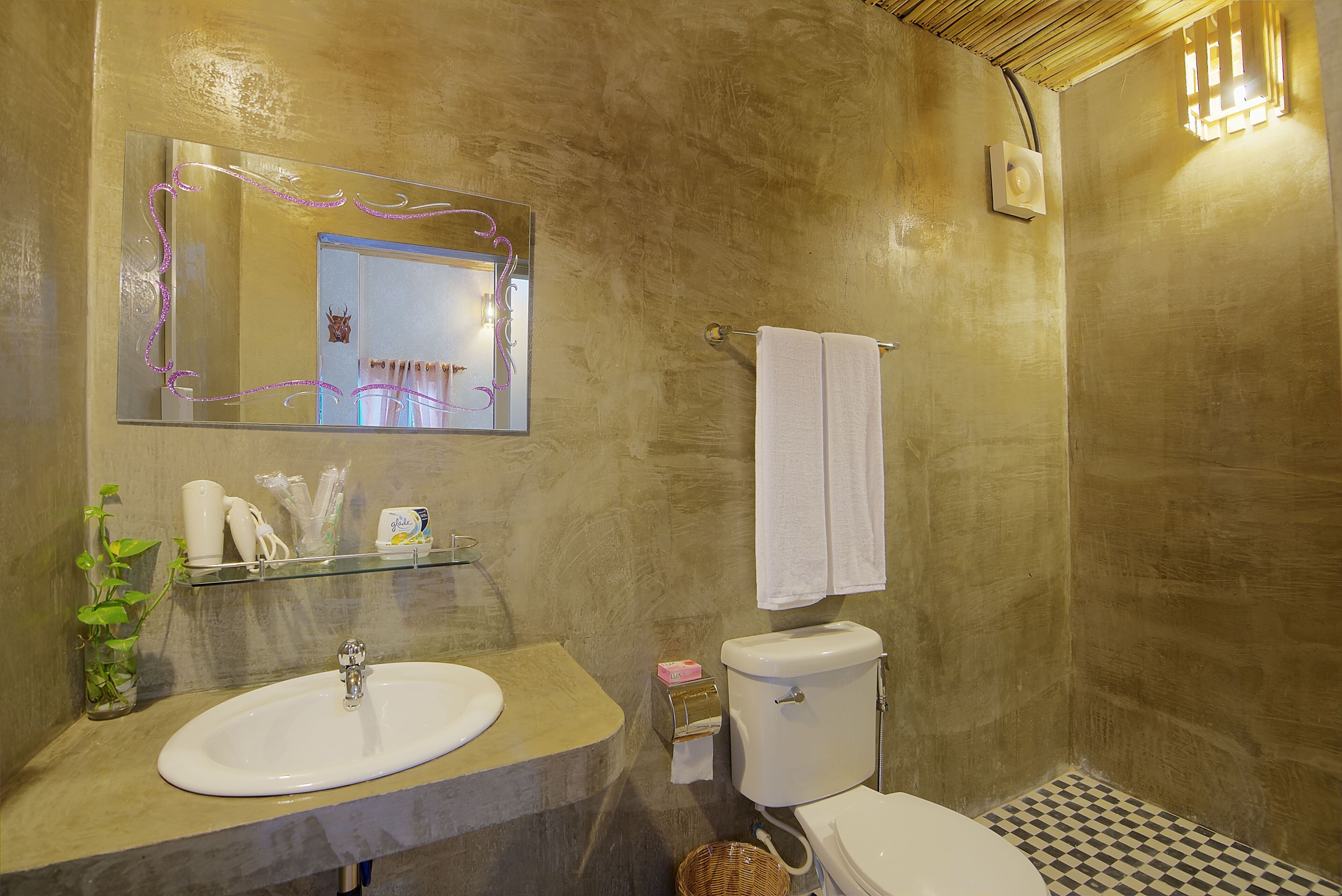 A bathroom with a sink, mirror, toilet, and a checkered floor.