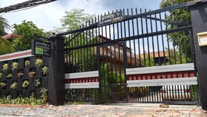 Ein verschlossenes Tor mit einem Schild für Old Khmer House 2, das es als Pension kennzeichnet.