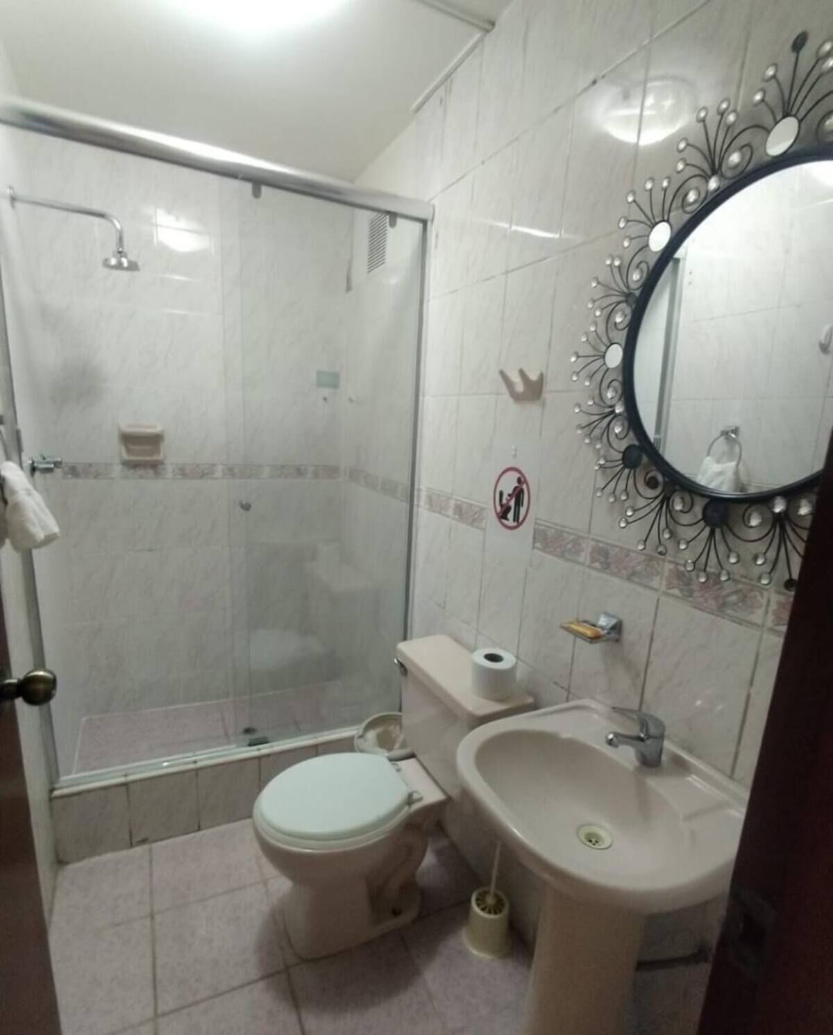 A bathroom with a shower, toilet, and sink.