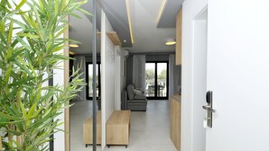 Un salon moderne avec un canapé, un banc en bois et une cloison en verre.