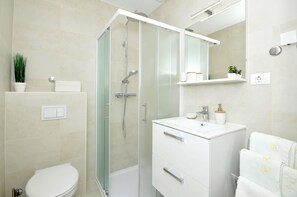 Regadera, secadora de cabello, toallas, papel de baño