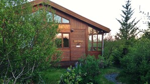 A wooden cabin with a large window and a sign that reads "HOTEL".