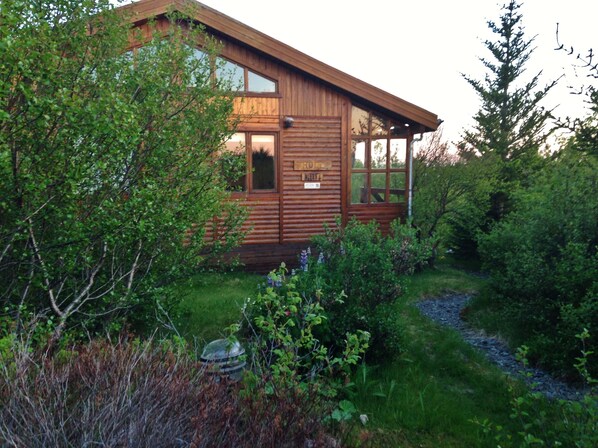 A wooden cabin with a large window and a sign that reads "HOTEL".