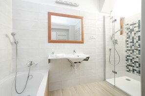 Bathtub, hair dryer, towels, toilet paper