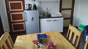 A compact kitchen with a refrigerator, a sink, and a small countertop. - Studio for rent in Cusco city center! (Cusco)
