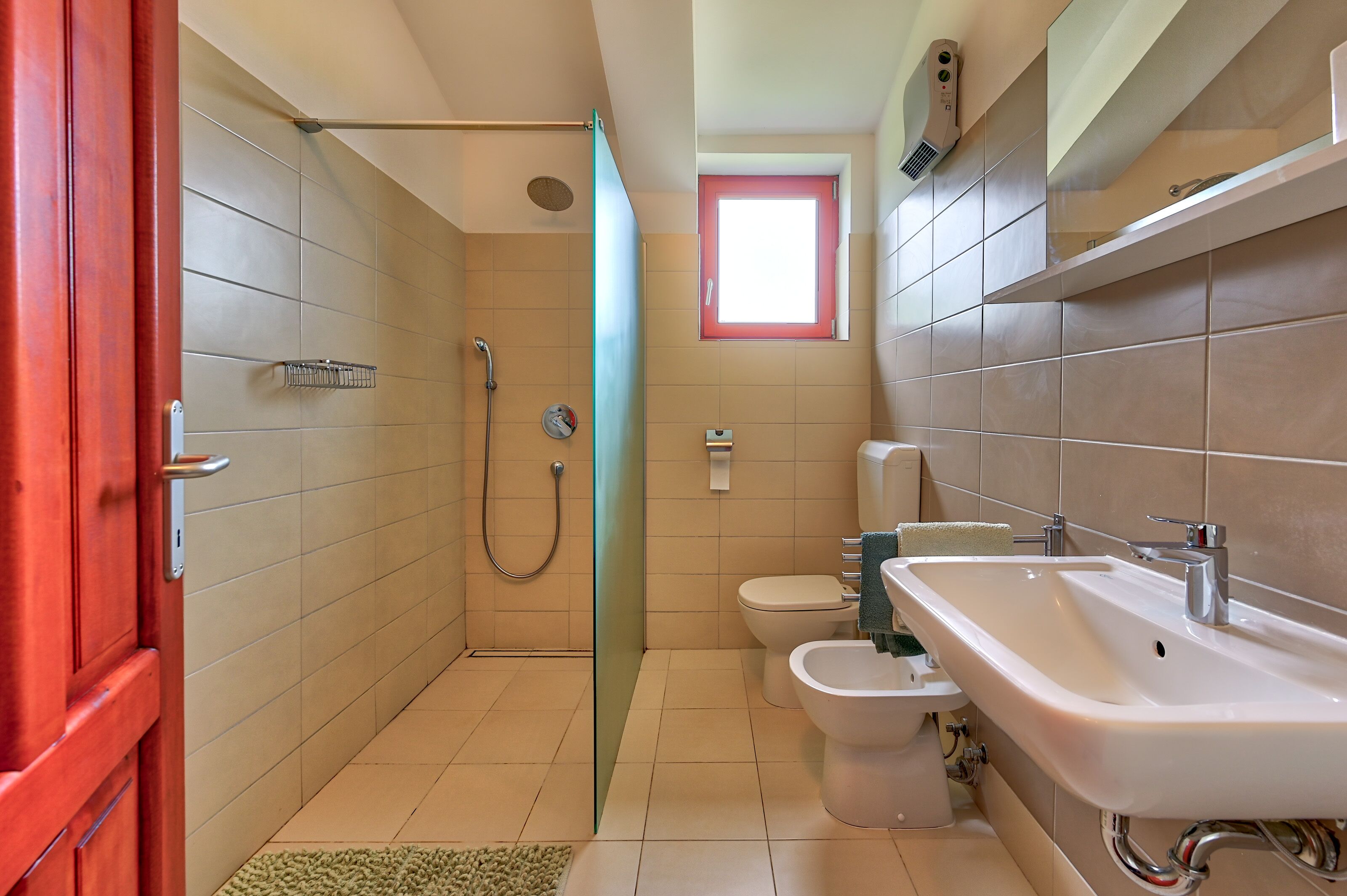 Ein Badezimmer mit Dusche, Toilette, Bidet und Waschbecken.