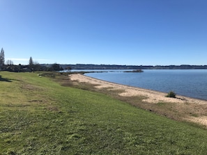 A grassy area beside a calm lake with a clear sky. - Comfortable character home near Rotorua lakefront, fast Wifi. (Rotorua)