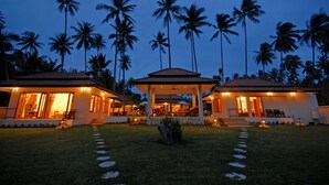 A resort with multiple villas, each featuring a covered patio and a swimming pool.