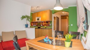 Un espacio habitable compacto con kitchenette, zona de comedor y área de estar.