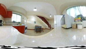 A spacious kitchen with a central island, a dining area with two stools, and a staircase leading to an upper level. - Great location for the adventurous traveler! (Maxwell)