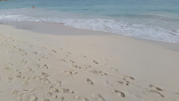 A sandy beach with footprints leading to the water. - Great location for the adventurous traveler! (Maxwell)