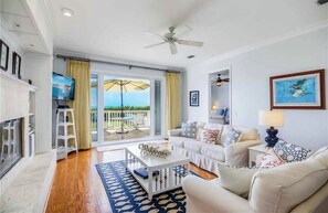 Relax in this stylish living area with a sliding glass door leading to a balcony and a cozy fireplace.