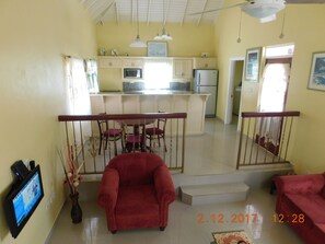 Relax in this inviting living space with a comfortable sofa, armchair, and flat-screen TV.