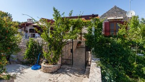 A stone building with a red roof, a gate, and a satellite dish. - Countryside Family Villa with Private Pool (Donje Selo)