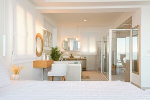 Relax in a serene space with a large bed, bedside table, and desk, featuring a large mirror above each.