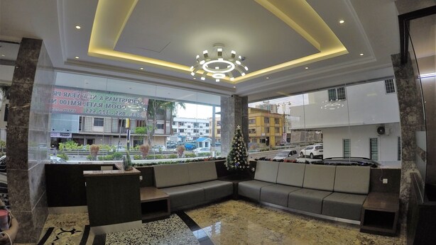 A hotel lobby with a large seating area, a Christmas tree, and a view of the street outside. - Nova Hotel Miri (Miri)