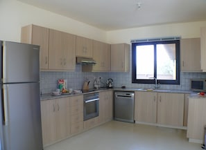 Enjoy cooking in this well-equipped kitchen with an oven, dishwasher, and refrigerator.