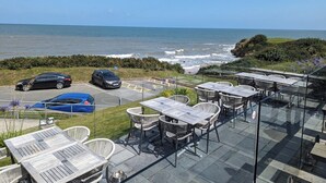 Een terras aan zee met buitenplaatsen en uitzicht op de oceaan.