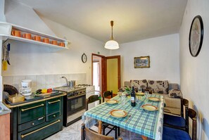 A kitchen with a dining table set for four, a stove, and a coffee maker. - Romantic Villa Angelina with a swimming pool and spacious garden. Pet friendly ! (Pićan, Jakačići)