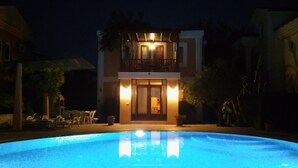 A two-story building with a swimming pool in front.